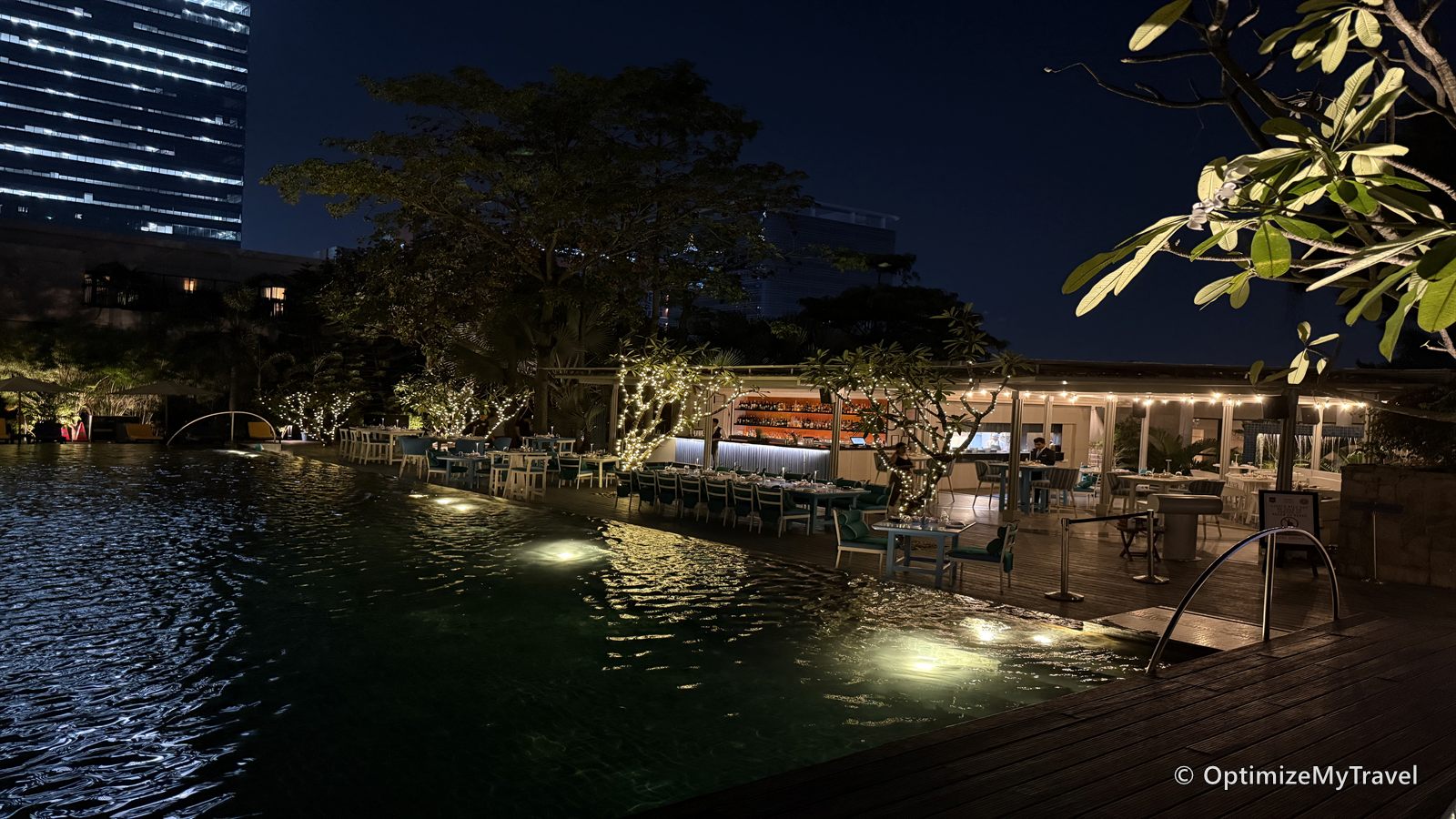 Outdoor swimming pool and poolside restaurant illuminated at night