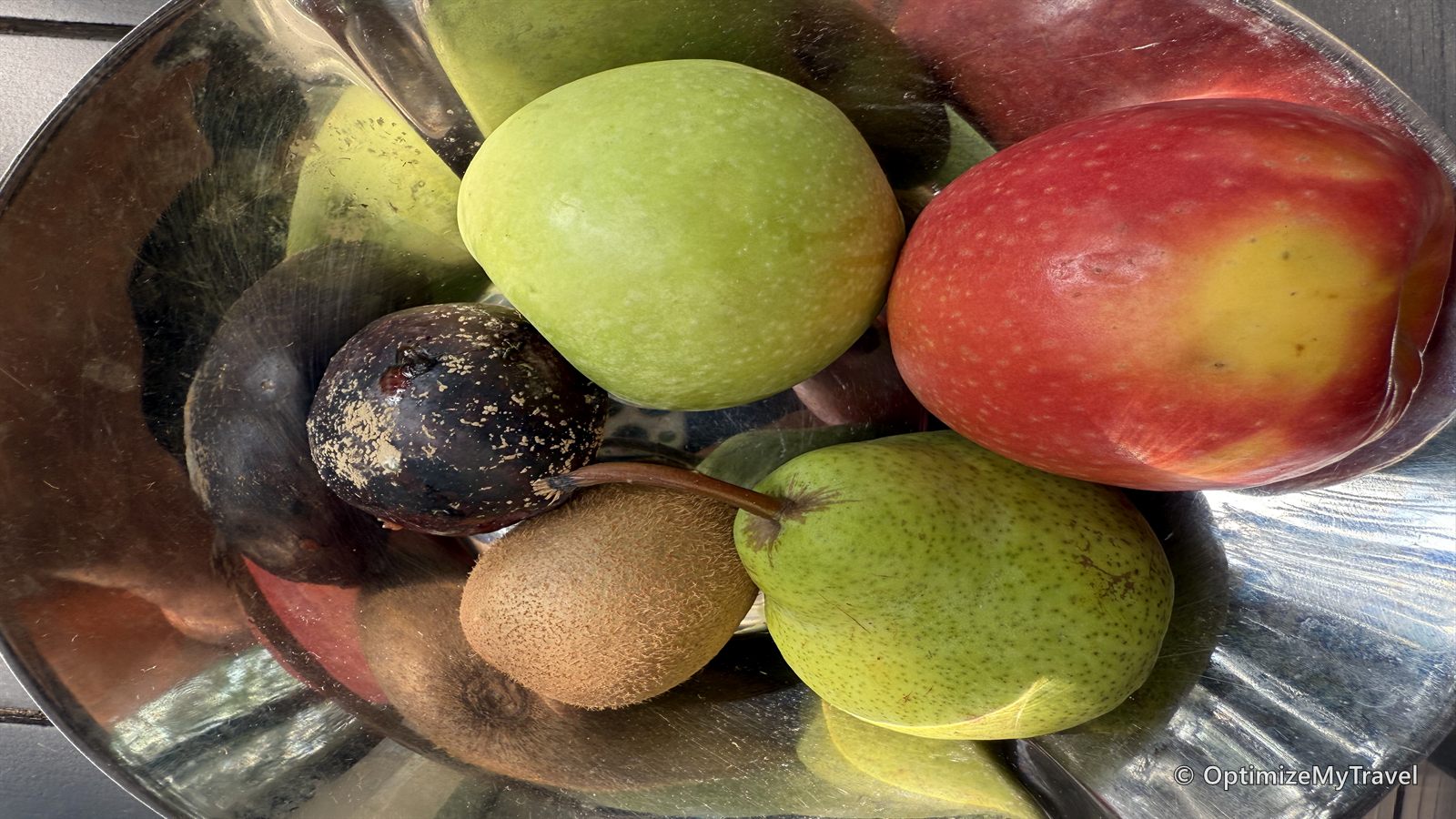 Hotel fruit tray containing visibly damaged dark-colored fruit