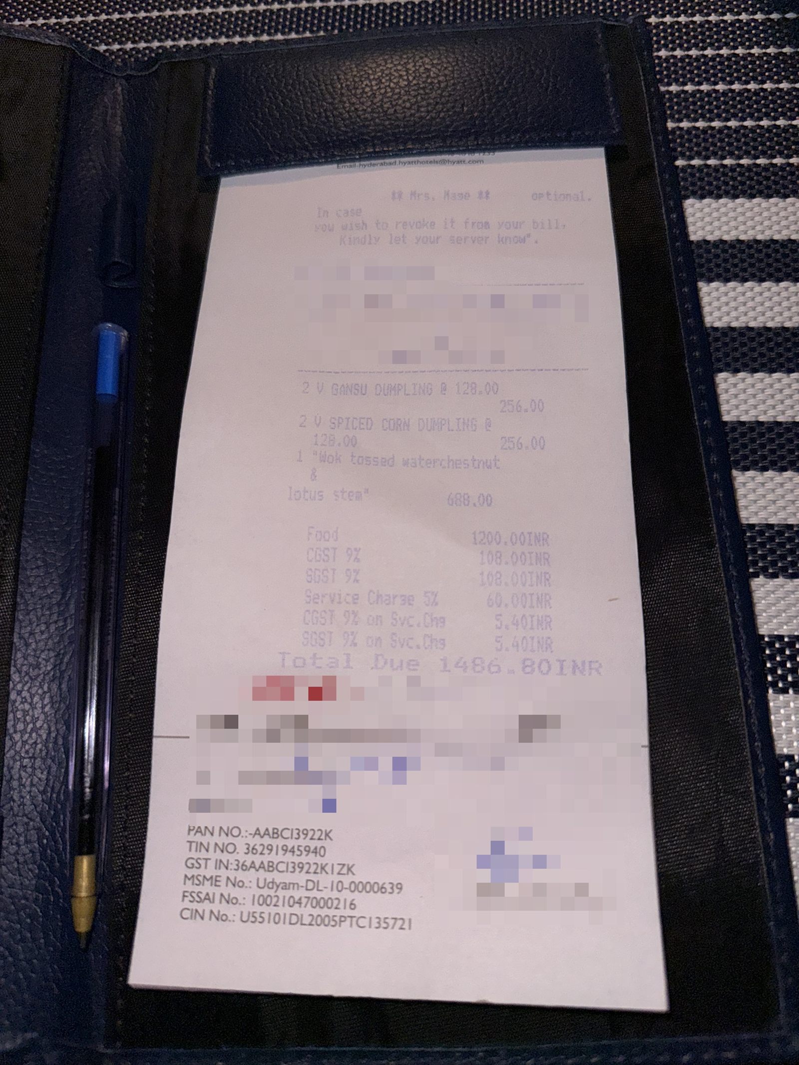 Restaurant bill showing food charges, Indian taxes, and an optional service charge