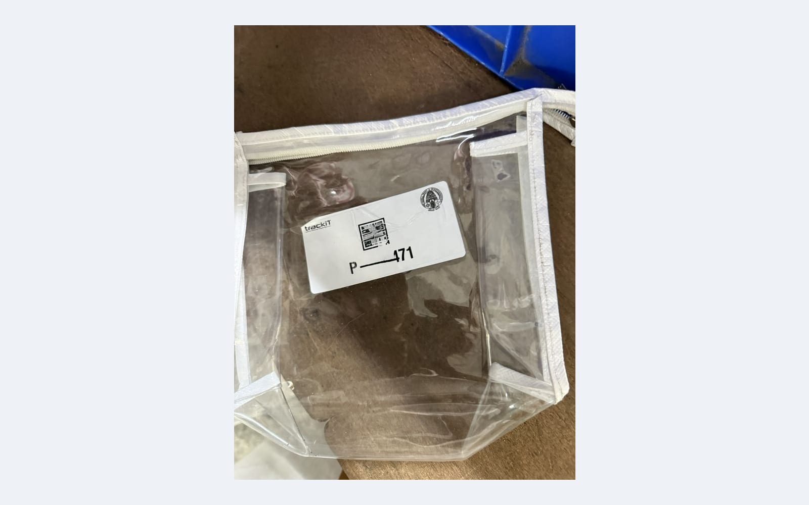 Trackit clear zip-lock pouch with QR-coded label used for phone deposit at Tirumala